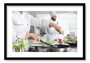Culinary arts meet precision as a chef sprinkles parsley over a gourmet dish, ensuring a balanced gastronomy with fresh herbs. Kitchen counter filled with raw materials and fresh produce.