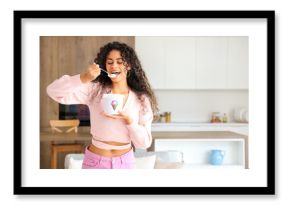 Beautiful young African-American woman with basket of ice cream in kitchen