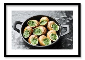 Delicious cooked snails in baking dish on grey textured table, closeup