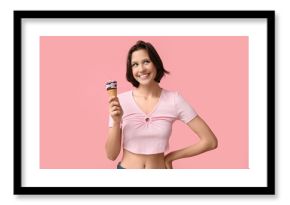 Happy young woman with sweet ice-cream in waffle cone on pink background