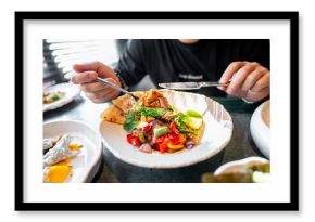 Close-up of a person enjoying a colorful and appetizing dish with vegetables and meat, garnished with fresh herbs. Perfect for culinary themes, showcasing healthy eating and the joy of food