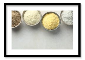 Different types of flour in bowls on light grey table, flat lay. Space for text