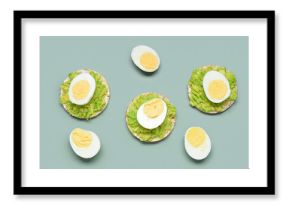 Rice crackers with boiled eggs and avocado on grey background