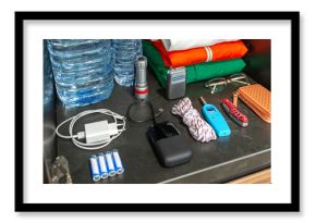 Banner of 72 hour survival kit in kitchen cupboard with water bottles, clothes, radio, batteries, powerbank, flashlight, knife and lighter. Full pantry ready for disasters, war, pandemic or blackout.