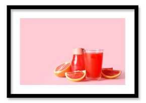 Glass and bottle with fresh grapefruit juice on pink background