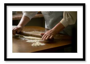 Old woman rolling dough on a table