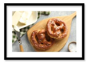 Tasty pretzels with salt and butter on light grey table, flat lay