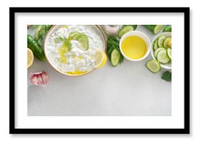 Tzatziki salad with roasted bread in white bowl on white background. Homemade Tzatziki salad with olive oil and copy space. Top view.