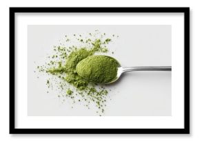 Top view of a spoon filled with green matcha on a white background