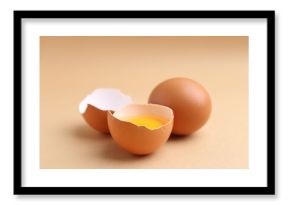 Whole and broken chicken eggs on beige background, closeup