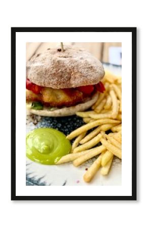 Pyszny fishburger podawany frytkami i sosem