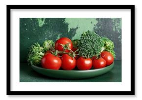 Broccoli and tomatoes arranged on plate with green artistic background, fresh healthy vegetables highlighting vibrant colors, perfect for food and nutrition concepts