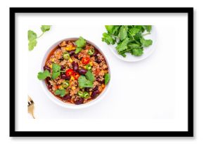 Spicy beef chili con carne with red beans, sweet corn, fresh cilantro, jalapeno pepper and tomato, served on white table, top view