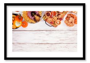 Thanksgiving appetizers, sweets and grazing boards. Above view top border on a white wood background. Pumpkin and apple snacks, pies, turkey cheese platter, desserts.
