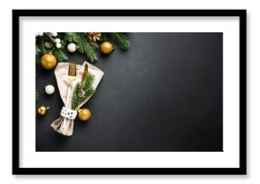 Modern golden cutlery and christmas decorations at black.