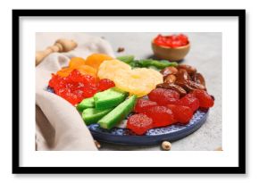 Plate with different candied fruits on grey background, closeup