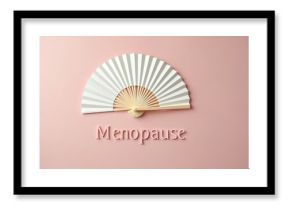 White folding fan rests near the word menopause on a pink background. Concept of hot flashes and cooling relief. Symbol of woman life stage.