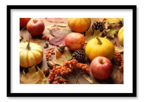 Dry autumn leaves, pumpkins, apples, acorns, pine cones and rowan berries on brown background, closeup