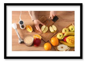 Young woman cutting fresh fruits for smoothie in kitchen