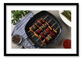 Skewers with tasty grilled vegetables served on grey table, flat lay