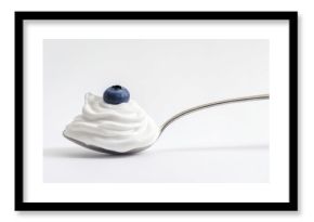 Silver spoon with greek yogurt or cream and fresh berry isolated on white background