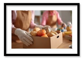 Volunteers pack grocery products for community food distribution event in local center during afternoon hours