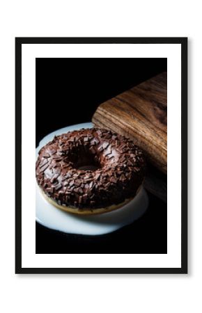 Double Chocolate Donut on White Plate with Wooden Cutting Board and Black Background