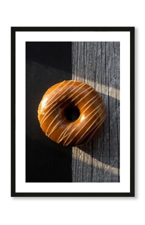 Caramel Glazed Donut with White Stripe Drizzle on Split Wood and Black Surface