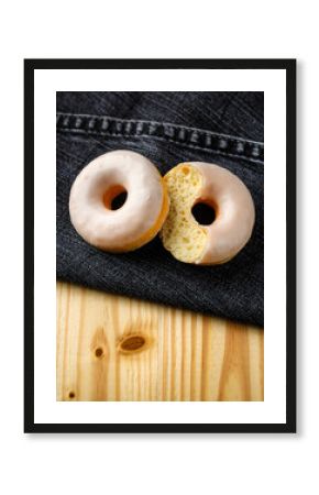Plain Glazed Donut with Bite on Denim Fabric and Wooden Table