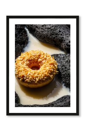 Gourmet Toasted Coconut Donut Dipped in Milk or Cream on Dark, Highly Textured Background
