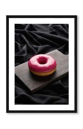Vibrant Pink Glazed Donut on a Dark Rustic Wooden Cutting Board