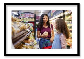 Latin mother and daughter doing grocery shopping together