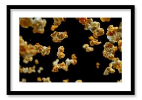 Dynamic macro shot of flying popcorn pieces against a black background. Crisp detail and motion captured in a dramatic, high-contrast composition. Perfect for advertising or creative design.