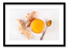 Homemade caramelized ginger jam marmalade preserves in small jar with fresh ginger roots on white table copy space