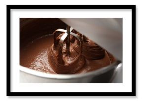 Mixing chocolate dough in bowl, closeup view