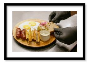 Preparing food. Restaurant culinary. Chef hand in glove adding sliced bread to served hot dish. Appetizing dinner with potato egg sausage.
