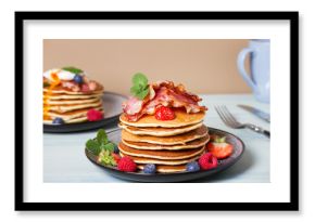 Fluffy pancakes with bacon, poached eggs and berries