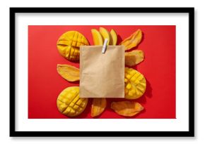 A paper bag with fresh and dried mangoes