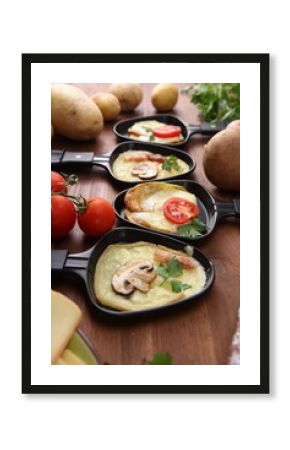 Delicious traditional Swiss melted raclette cheese served in individual skillets with salami and bacon