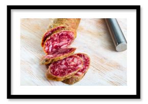 Popular Spanish salchichon sausage sliced on wooden background