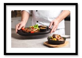 Professional chef serving dish at table indoors, closeup