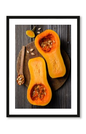 Top view of raw butternut squash with wooden spoon and seeds on wooden cutting board. Halfs of pumpkin close up. Food photography