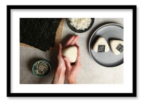 Woman making tasty onigiri (Japanese rice balls) at light table, top view