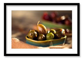 Olives, homemade marinated colorful olives with herbs and spices on rustic table, close up. Healthy Mediterranean vegan food. 