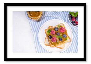 Pistachio paste toast. Summer breakfast delicious sandwiches with pistachio butter spread, with fresh berries. Balanced healthy vitamins and macronutrients snack