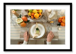 Young woman at served table prepared for dinner in room. Closeup