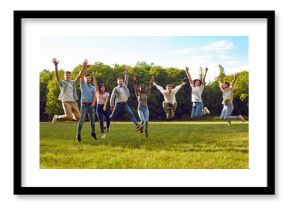Group of diverse people having fun in summer park. Several happy carefree excited cheerful joyful young multiracial friends jumping together on grassy lawn in green park under blue sky