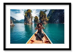 happy young woman tourist in asian hat on the boat at lake