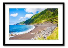 Black sand volcanic beach of Faja and green tropical landscape with high cliffs on ocean coast, Faial island, Azores, Portugal