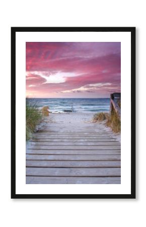 a footpath of wooden planks to the beautiful beach at the sea, amazing sunset light